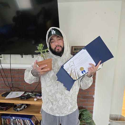 Mr. Ortiz holding certificate and jade plant.